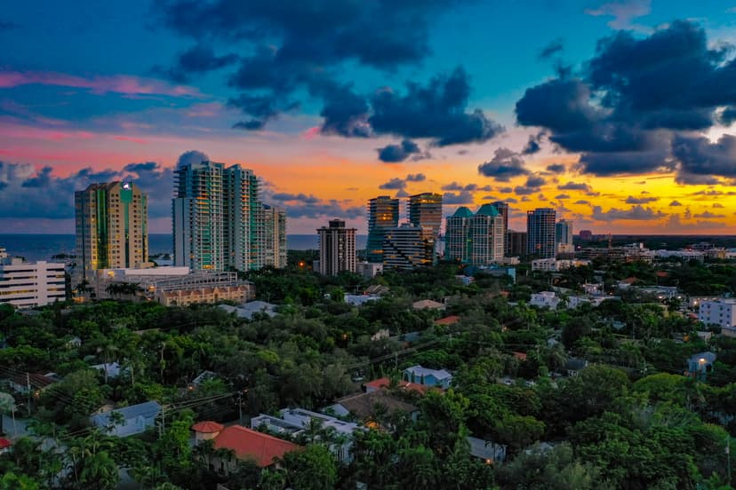 Aerial view of Coconut Grove marina with high‑rises and palms; contrasted with Coral Gables’ Mediterranean elegance in the story.